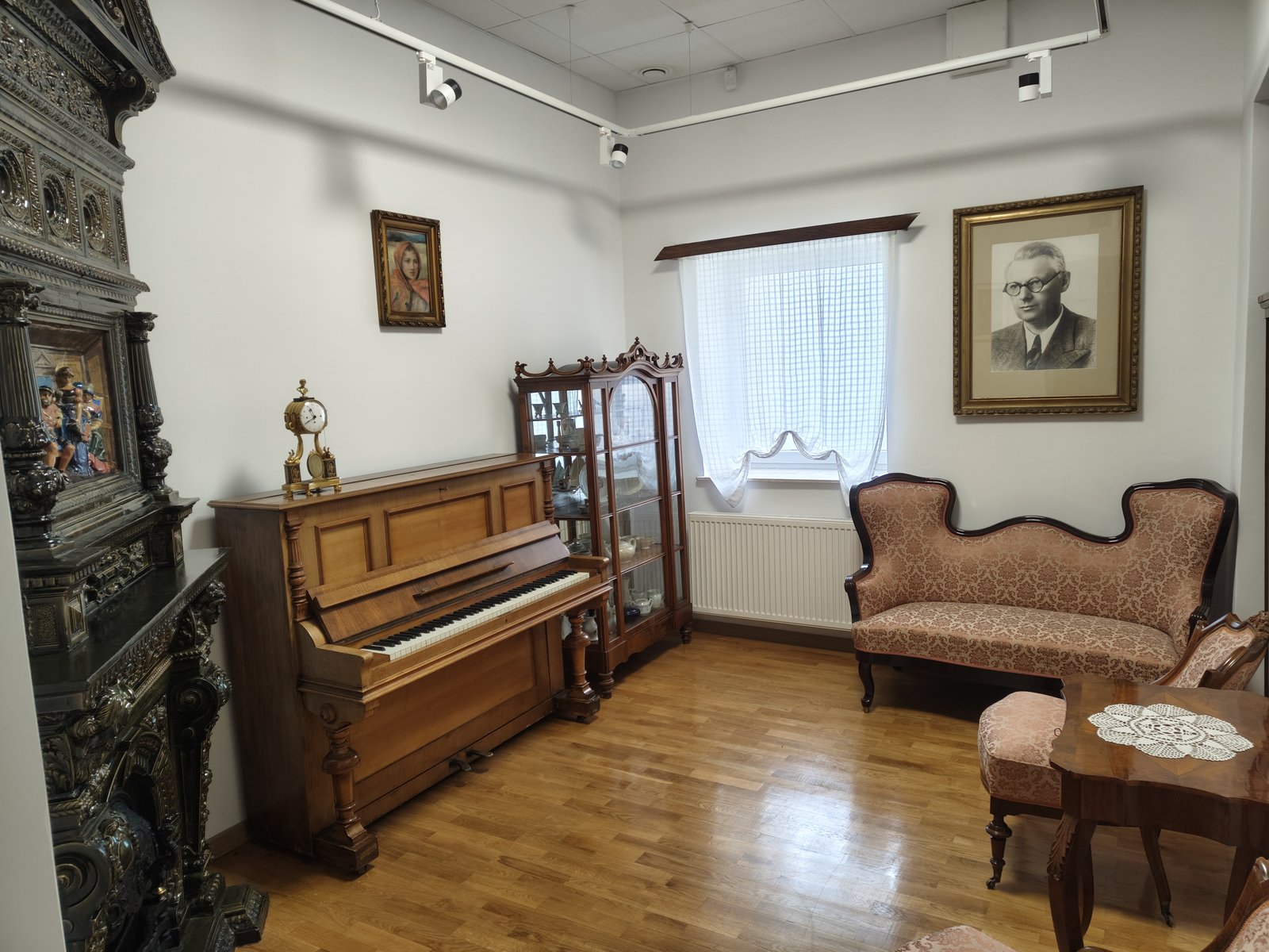 Salonik dr. Janusza Petera z pianinem, kanapą, piecem kaflowym i portretem założyciela w muzeum w Tomaszowie Lubelskim